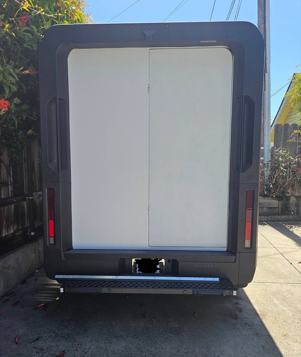 Rear of a BrightDrop van with the roll-up door replaced by a flush panel wall